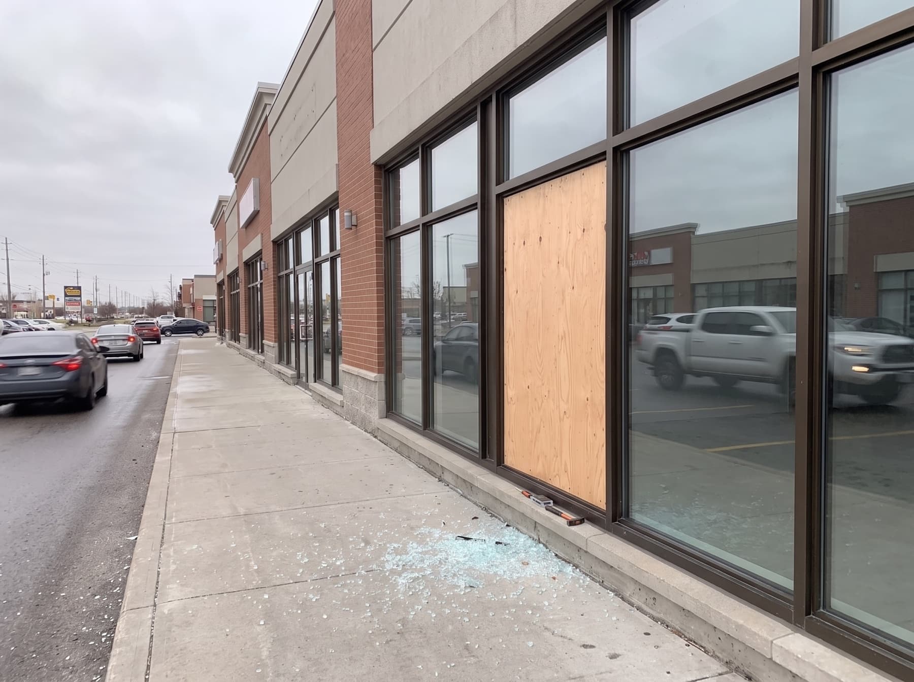 Pickering urban storefront with plywood board-up after emergency glass breakage