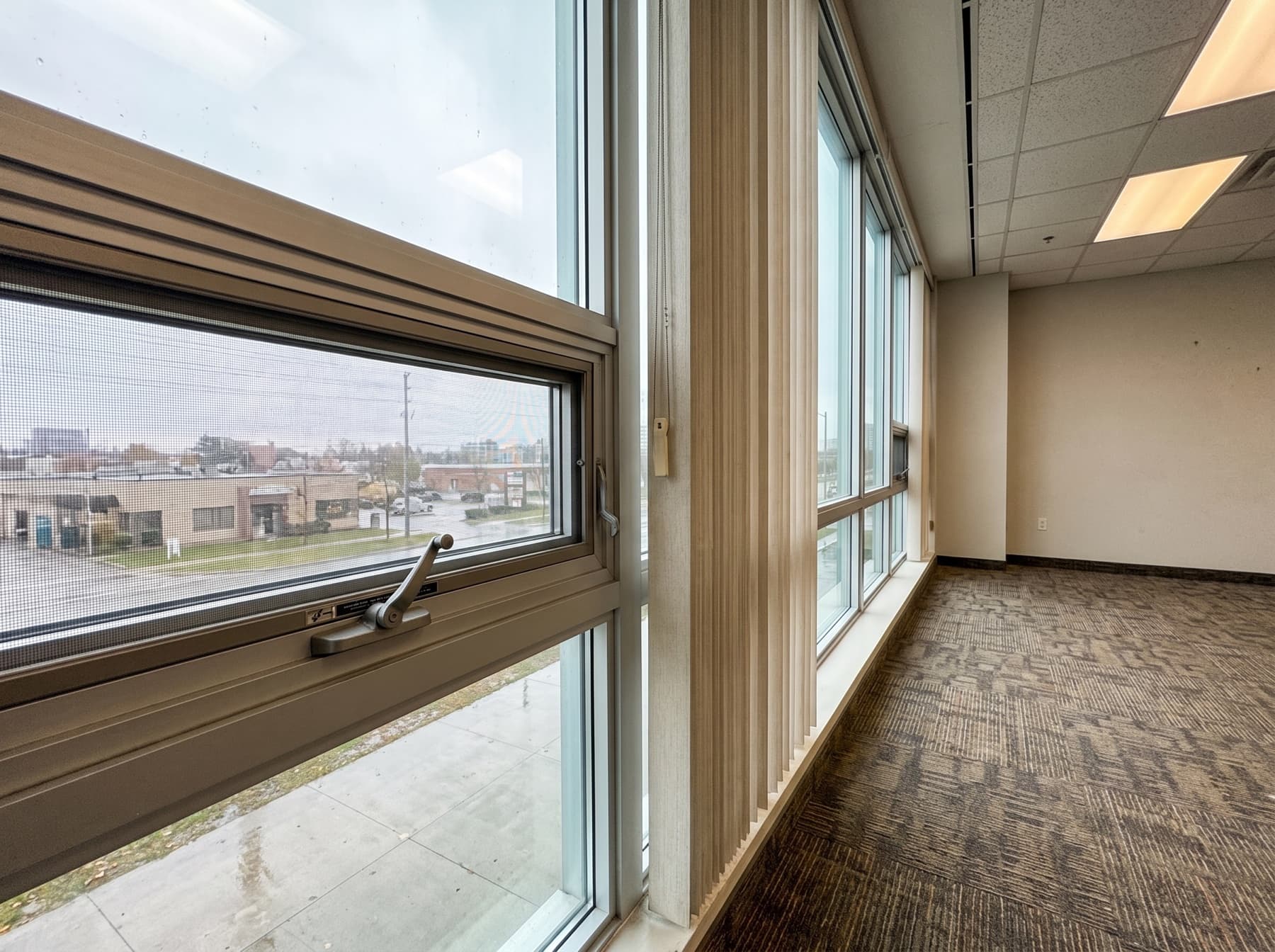 Interior Richmond Hill office window with crank operator and latch hardware on the inside frame